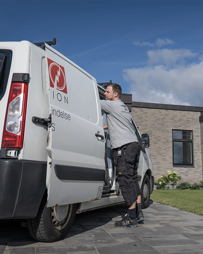 Elektriker fra Uggerly Installation der arbejder ved sin servicevogn.