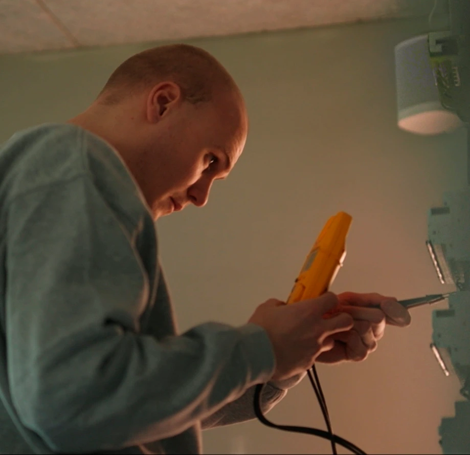 Elektriker fra Uggerly Installation, som er ved at udfører et El-tjek for en kunde.